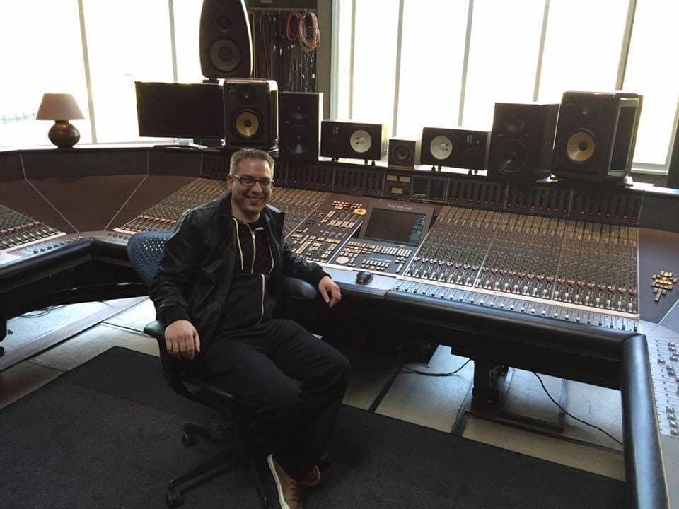 Ric Hertz seated at a large-format mixing console