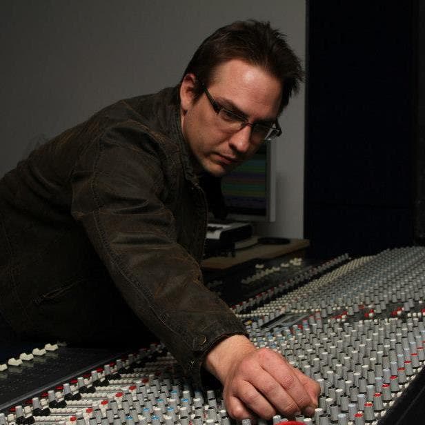 Ric Hertz working a console, hands on the faders