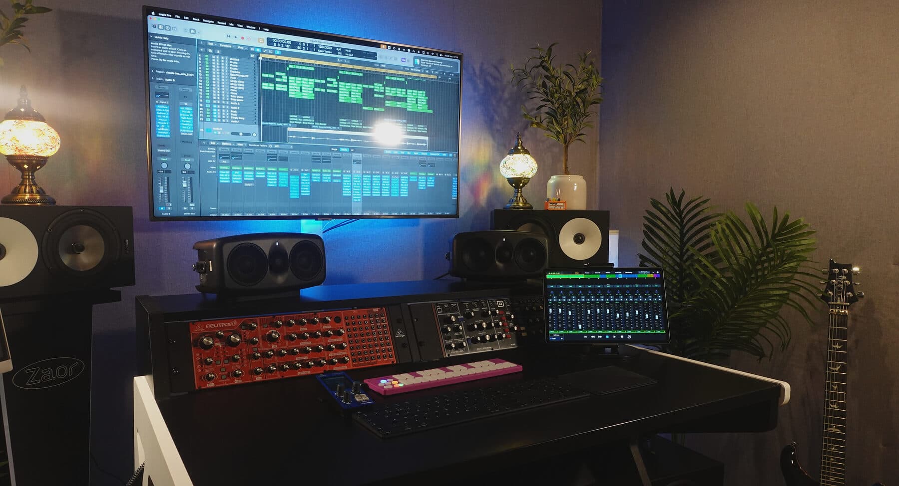 The finished mastering room — fabric-walled, with Amphion monitoring flanking the screen and the desk at the listening position